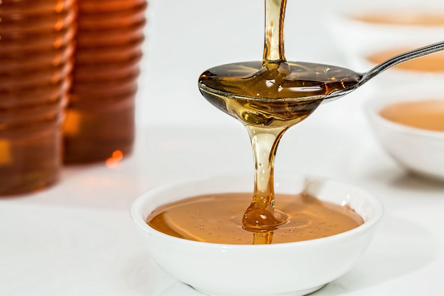 honey overflowing from a spoon into a jar